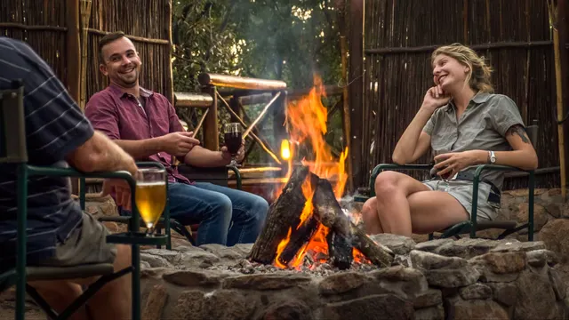 Guests gathered around a lit boma fire after dark